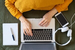 Detalle de las manos de una mujer escribiendo en su notebook