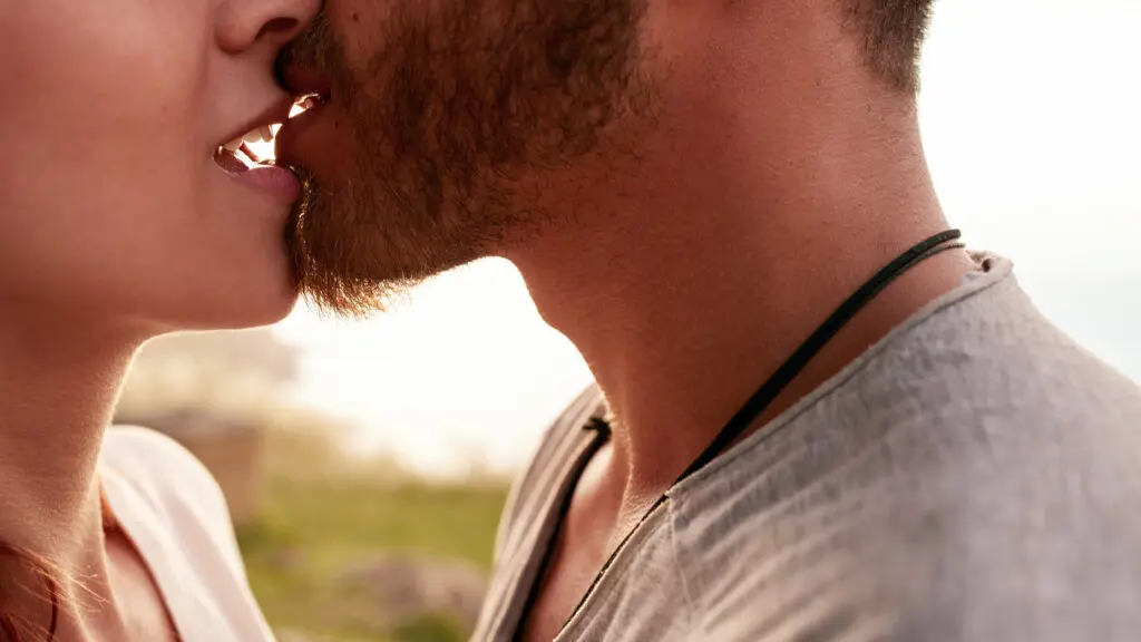 Primer plano del beso de una pareja entre un hombre y una mujer.